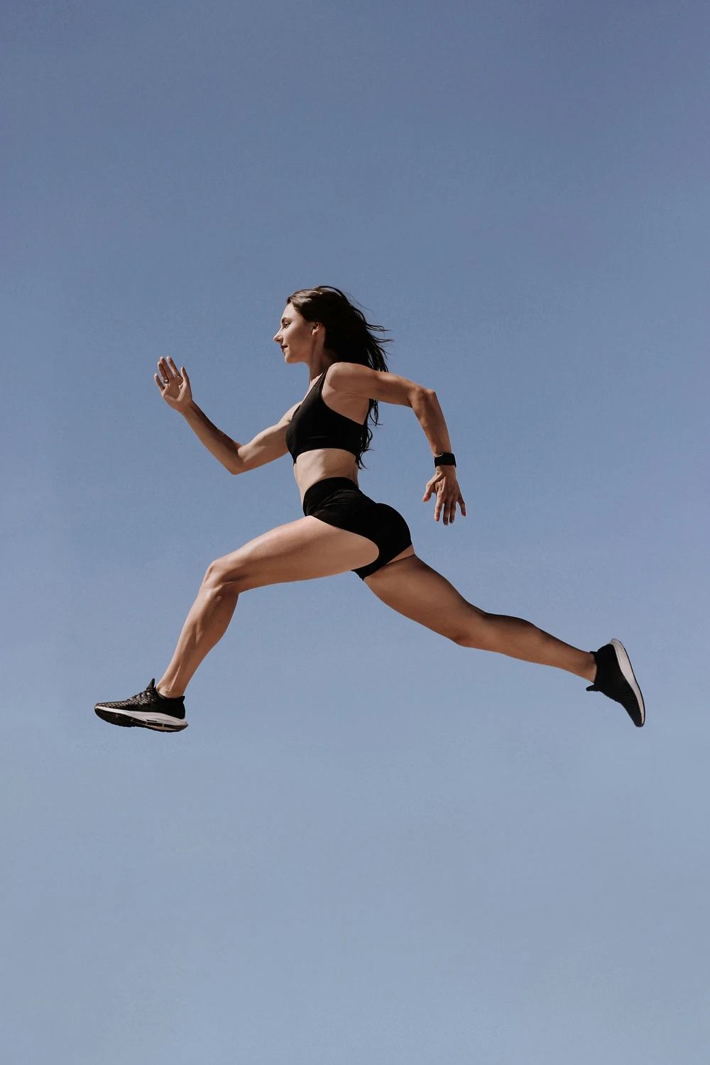 A teenage girl in athletic wear is leaping and running, preparing to take the Presidential Fitness Test.